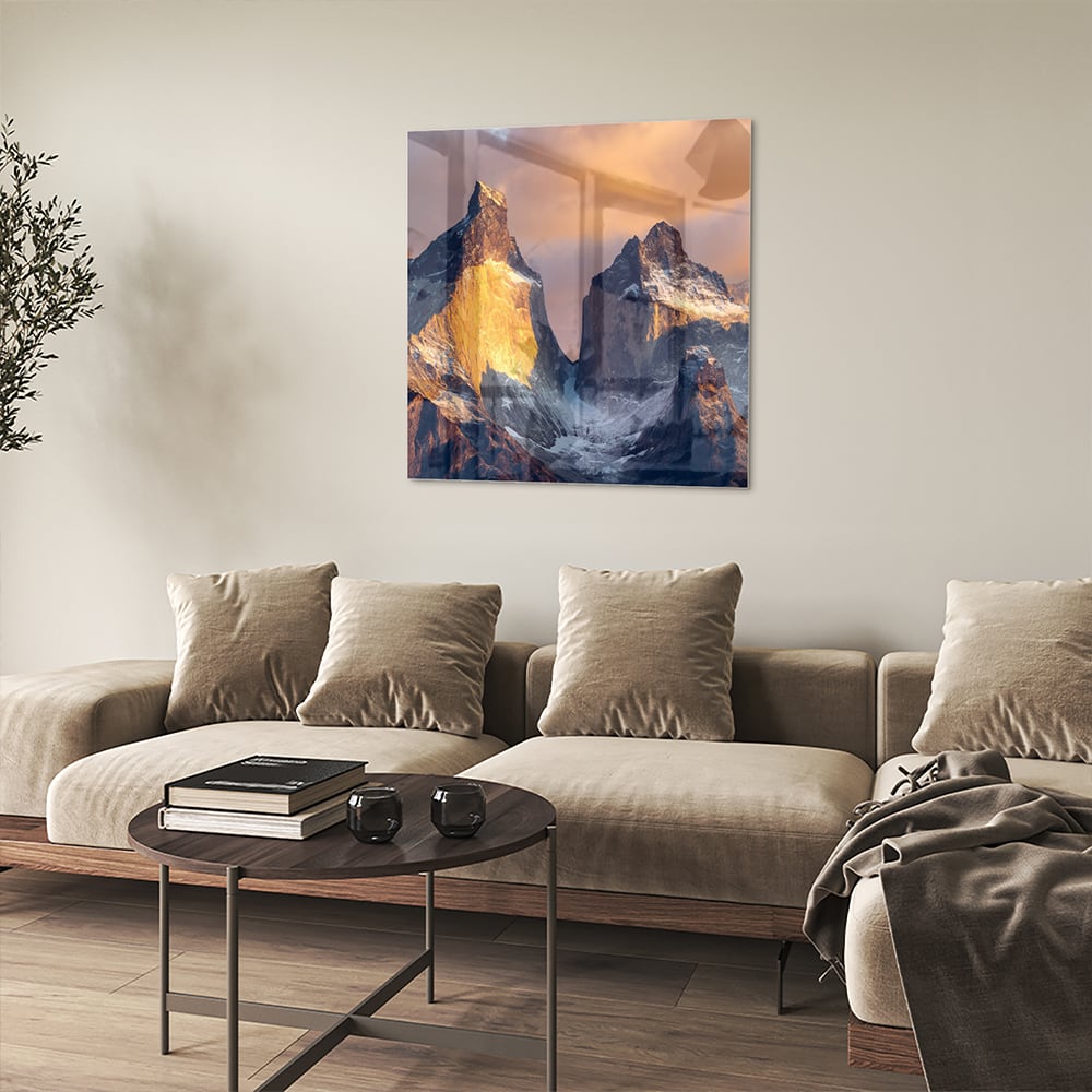 Een glazen schilderij van majestueuze bergen met gouden ochtendlicht