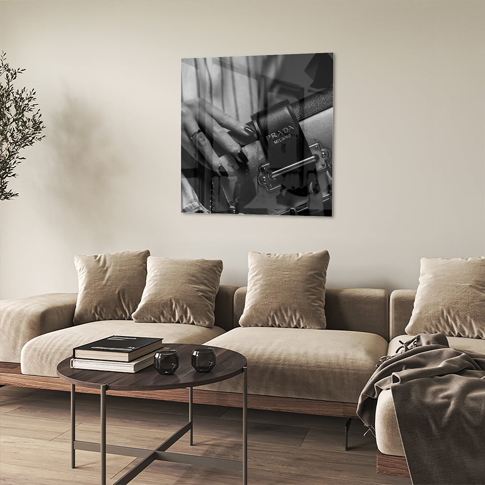 Glazen schilderij met close-up van luxe accessoires op een wand.