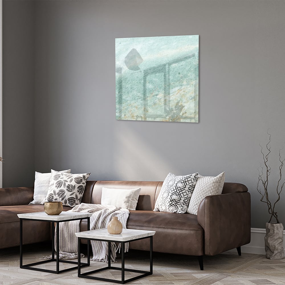 Abstract glazen schilderij in groentinten aan de muur in een moderne woonkamer.