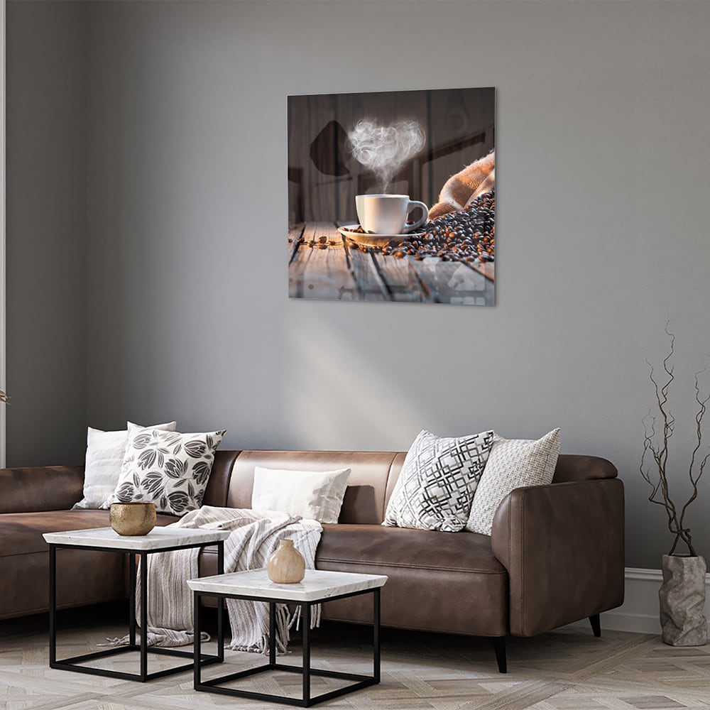 Glazen schilderij met een dampende kop koffie en koffiebonen op een houten tafel.