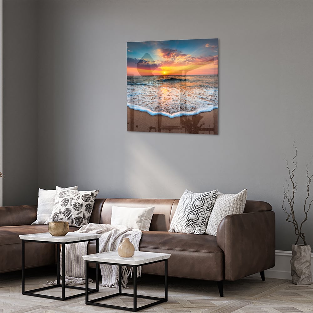 Glazen schilderij van een zonsondergang boven de zee met een warme kleurenpalet.