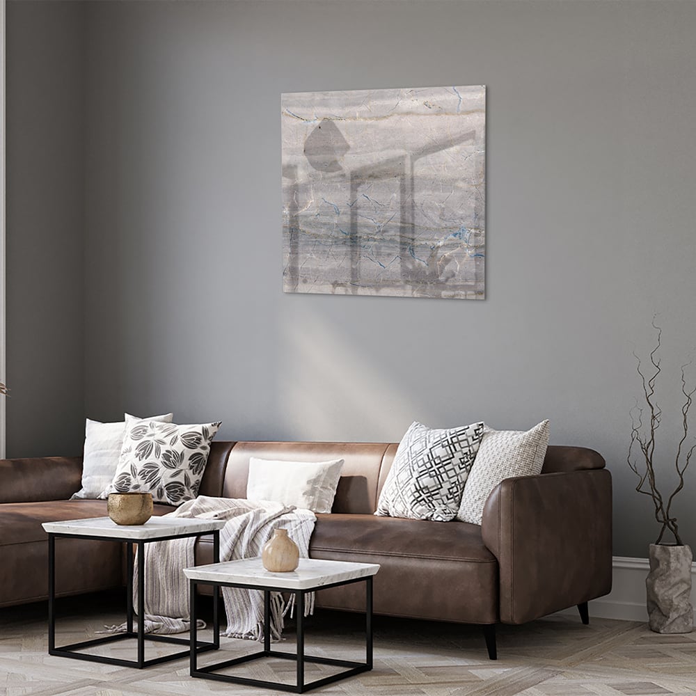 Glazen schilderij in aardetinten hangt aan de muur in een moderne woonkamer.