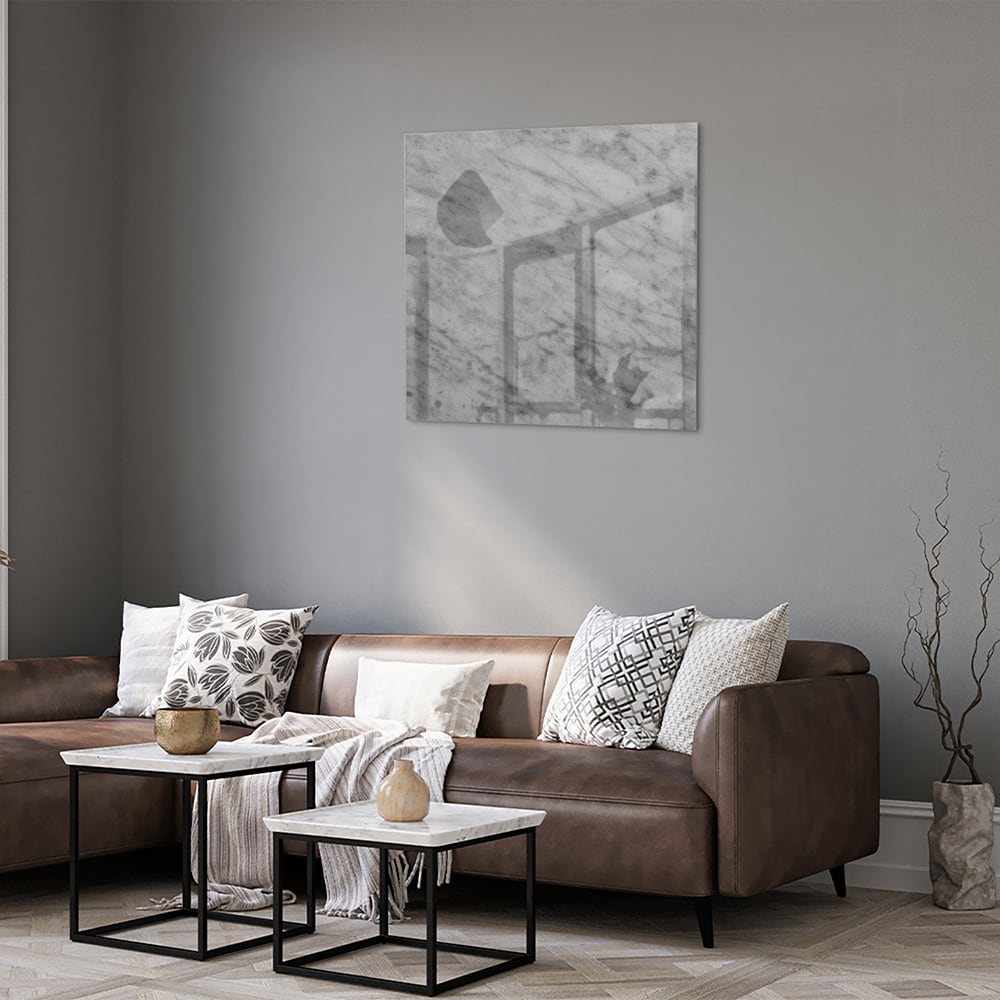 Glazen schilderij met marmerlook in een stijlvolle woonkamer met een houten meubel.