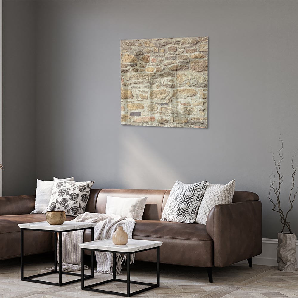 Glazen schilderij van een rustieke stenen muur in een lichte woonkamer.