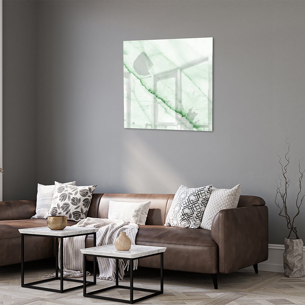 Glazen schilderij met een groene marmerlook aan de muur in een moderne woonkamer.