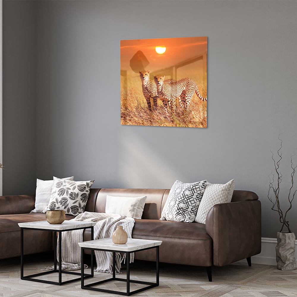 Glazen schilderij van twee cheeta's in een gouden savanne bij zonsondergang.