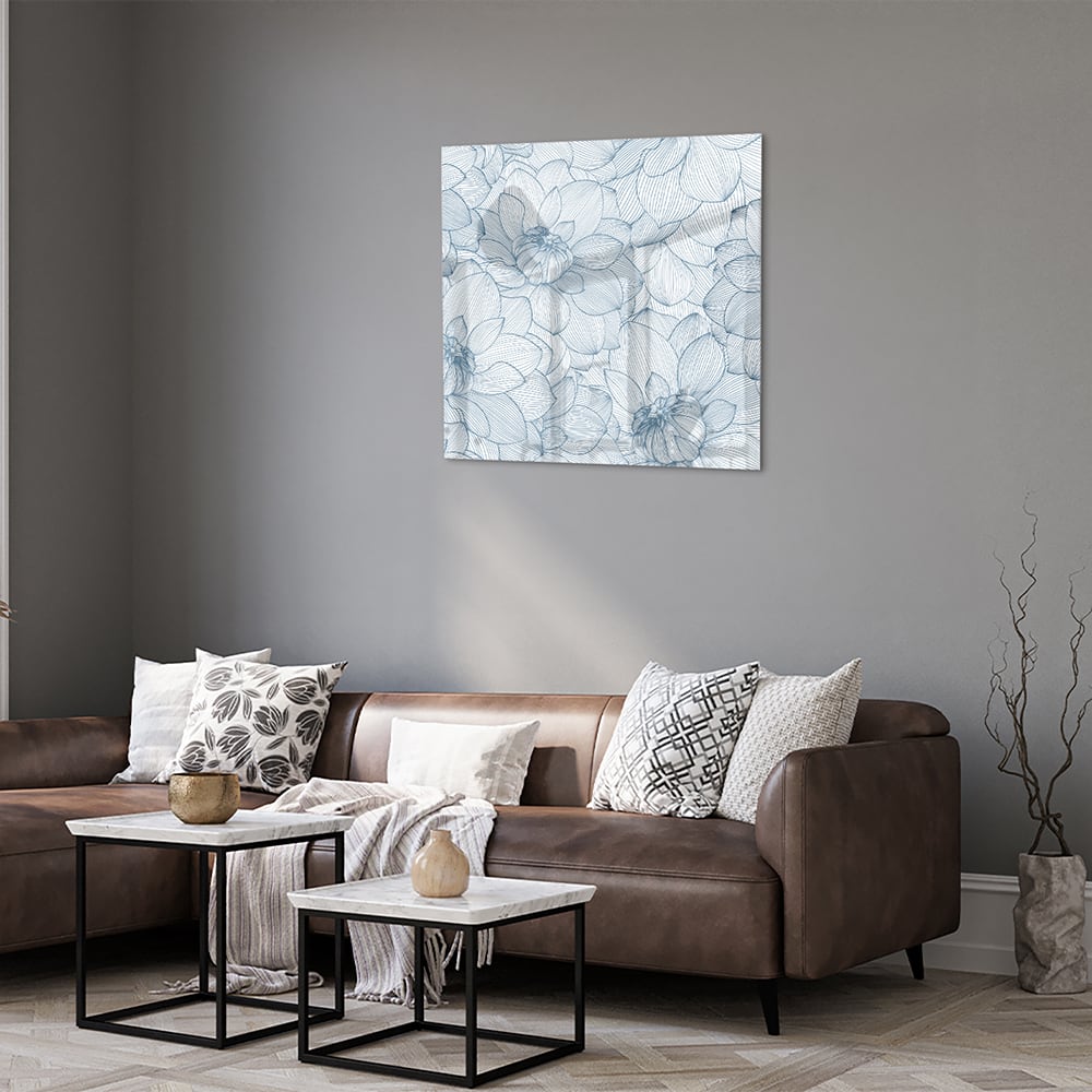 Glazen schilderij met bloemenpatroon in zachte blauwe kleuren, staat boven een houten kast.