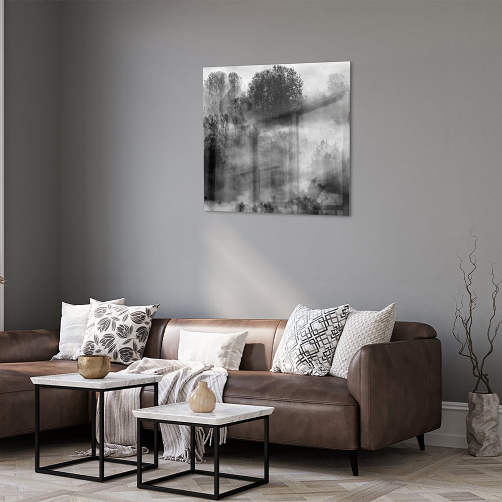 Glazen schilderij met een abstract zwart-wit landschap van bomen in de mist.