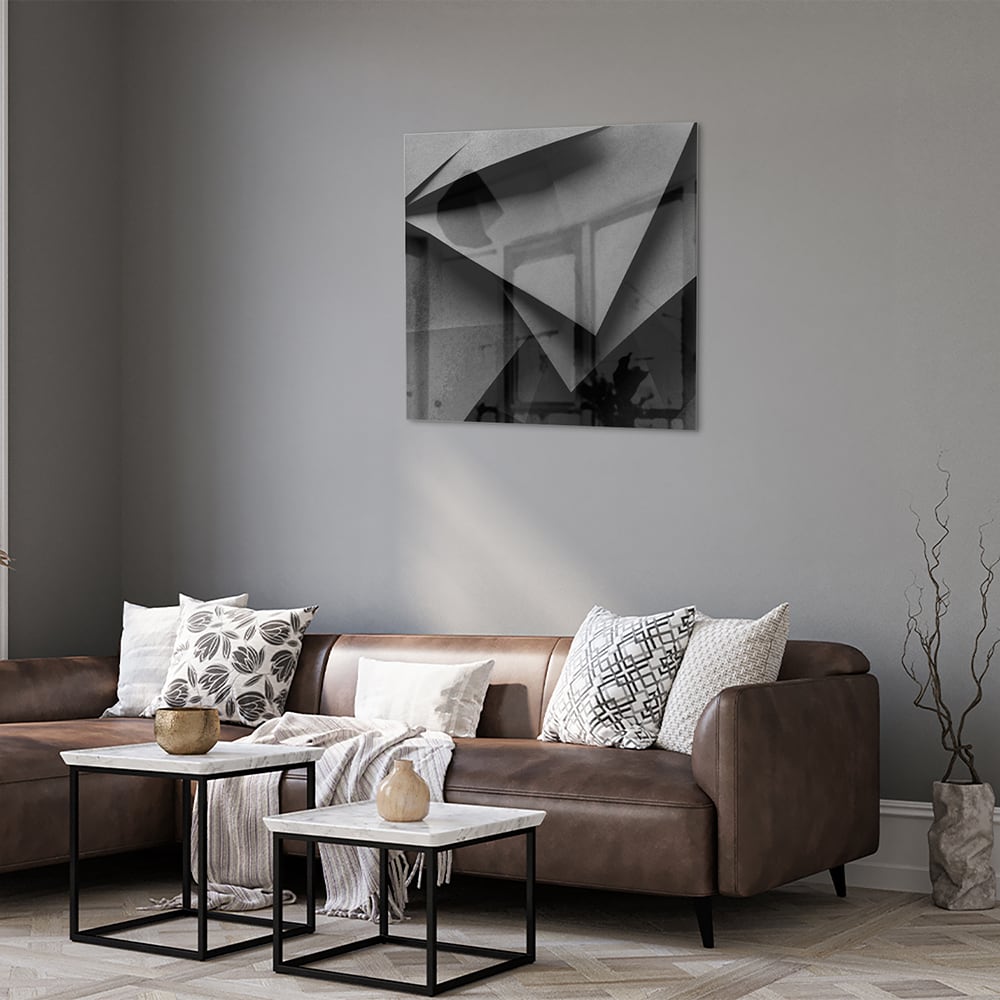 Modern glazen schilderij met een geometrisch zwart-wit ontwerp aan de muur.
