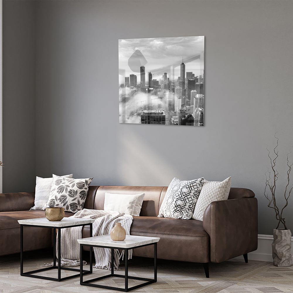 Glazen schilderij van een stads skyline in zwart-wit met wolken.