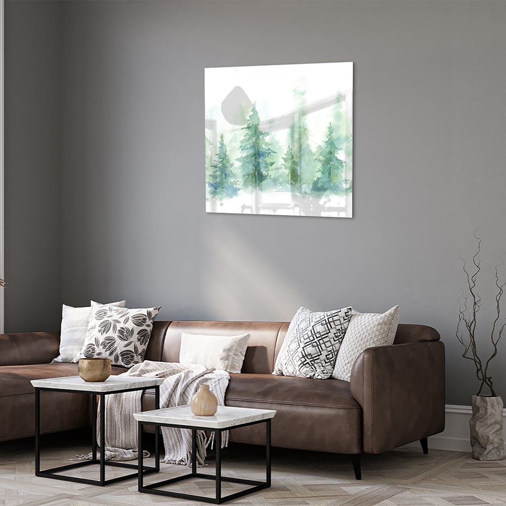 Glazen schilderij met groene dennenbomen aan de muur in een modern interieur.