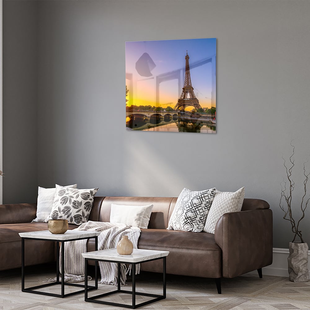 Een glazen schilderij van de Eiffeltoren bij zonsondergang, met warme kleuren.