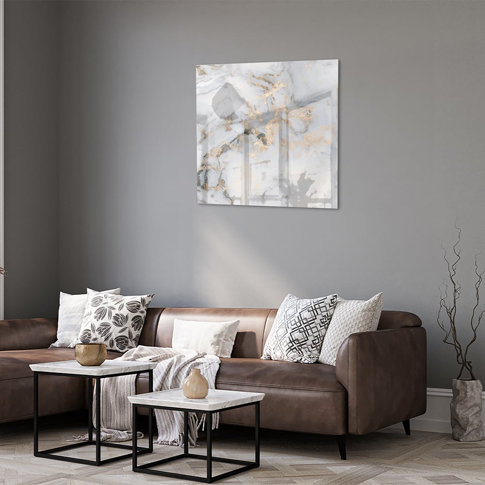 Glazen schilderij met marmerlook en gouden accenten aan de muur.