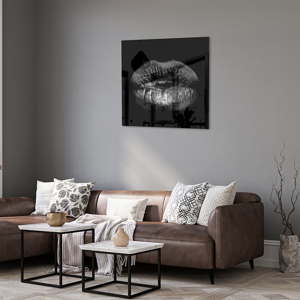 Zwart glazen schilderij met een artistieke lippenprint aan de muur.
