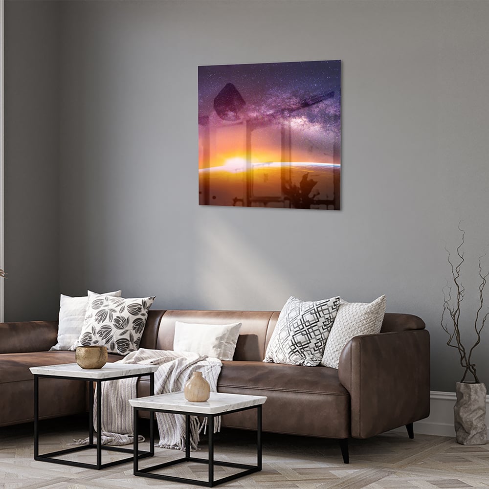 Glazen schilderij van een sterrenhemel met zonsondergang, hangt aan de muur in een stijlvolle woonkamer.