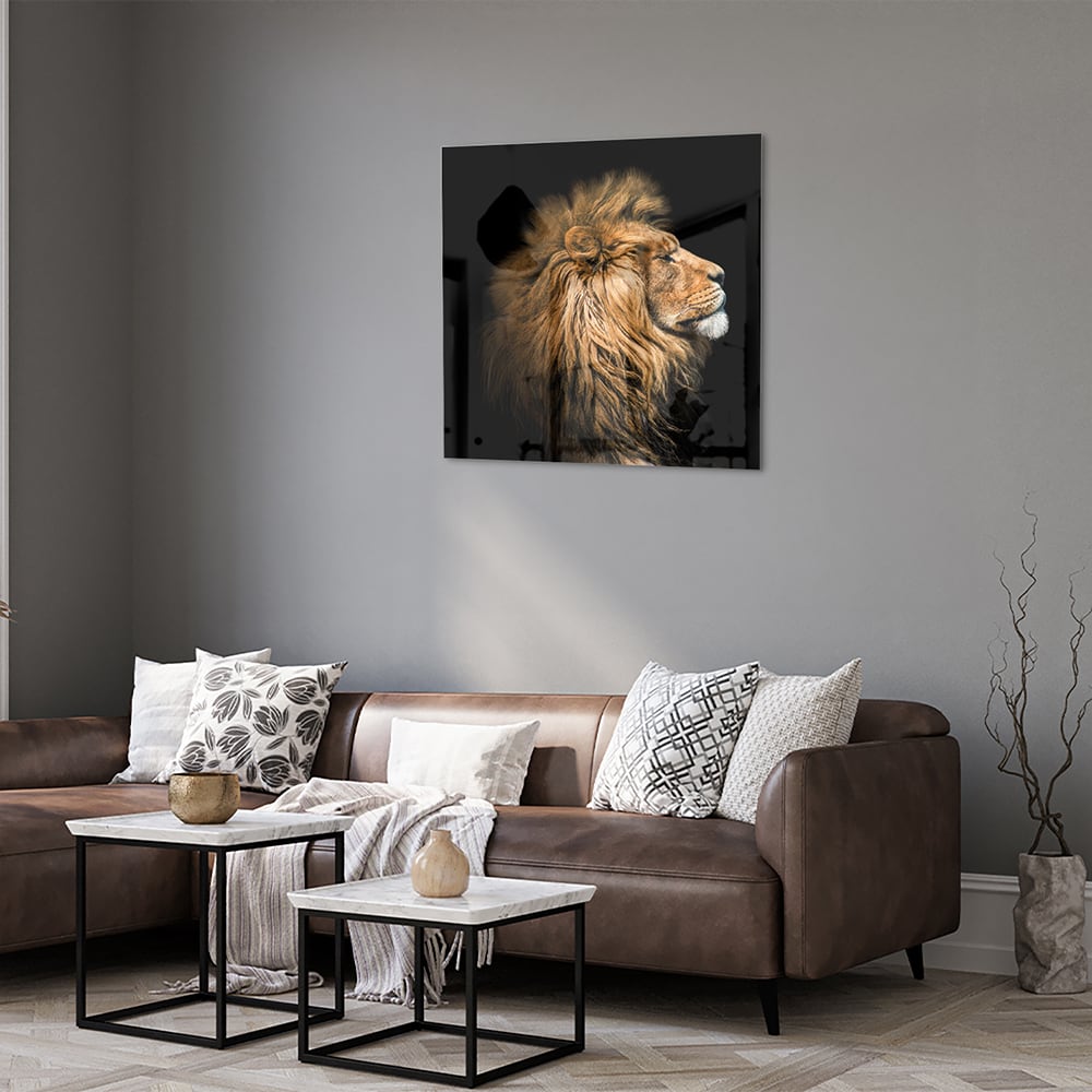 Glazen schilderij van een leeuw met rijke, gouden manen tegen een zwarte achtergrond.