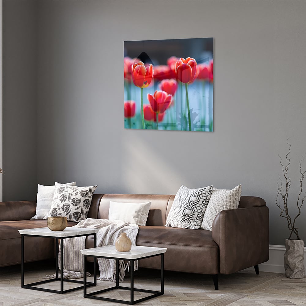 Glazen schilderij met rode tulpen op een witte muur