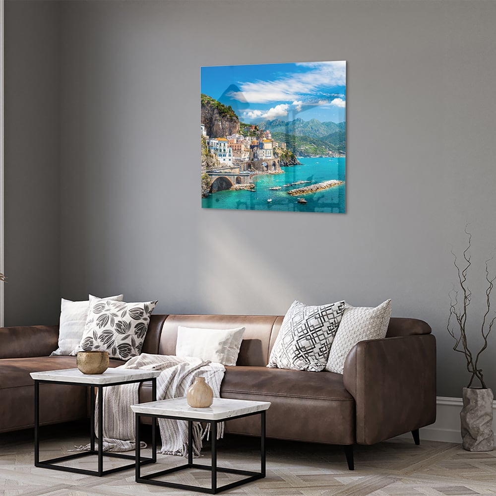 Glazen schilderij van een kustlandschap met blauwe zee en groene bergen.
