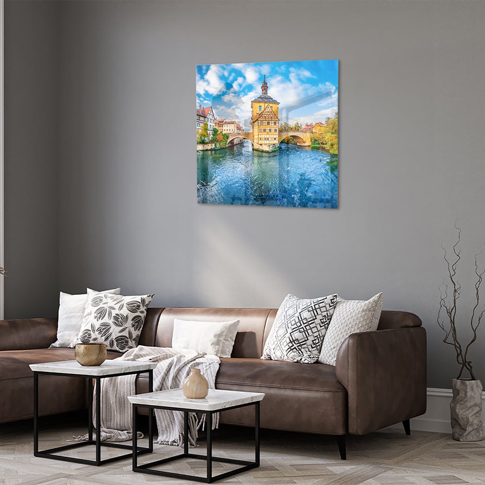 Glazen schilderij van een schilderachtig stadje aan het water met kleurrijke gebouwen en een helderblauwe lucht.