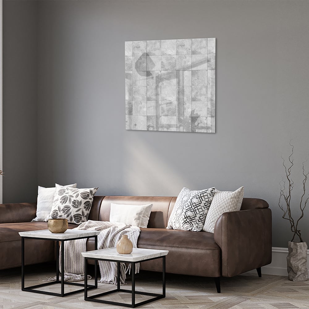 Abstract glazen schilderij in grijstinten aan de muur boven een houten dressoir.