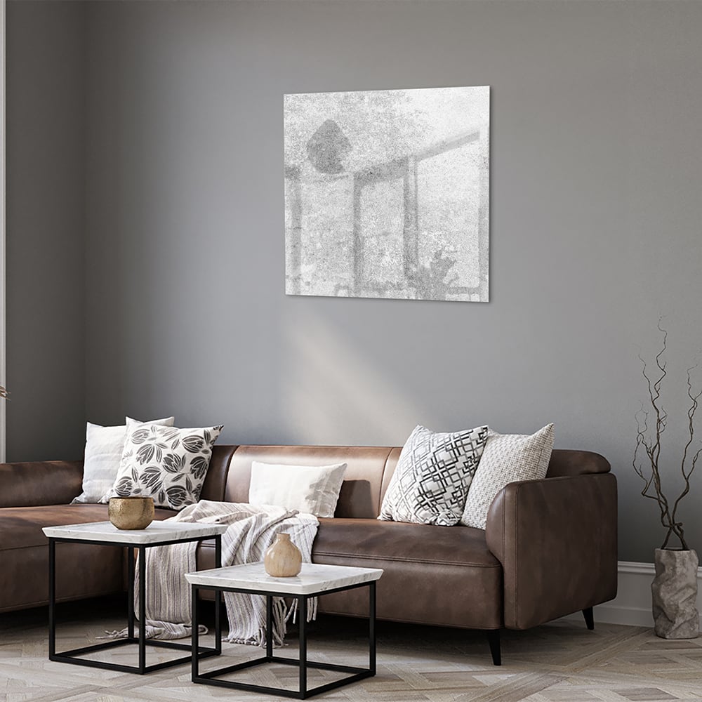 Abstract glazen schilderij met een subtiele textuur aan de muur in een moderne woonkamer.
