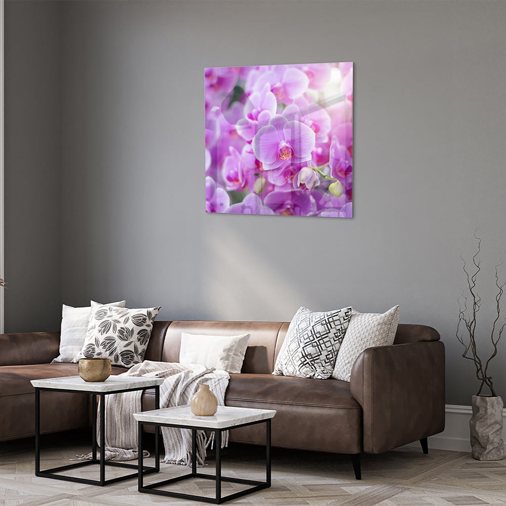 Glazen schilderij met een close-up van paarse orchideen in een mooi interieur