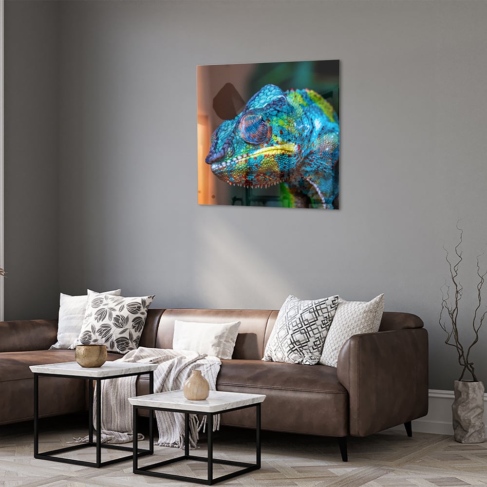 Glazen schilderij van een kleurrijk chameleon hangt aan de muur
