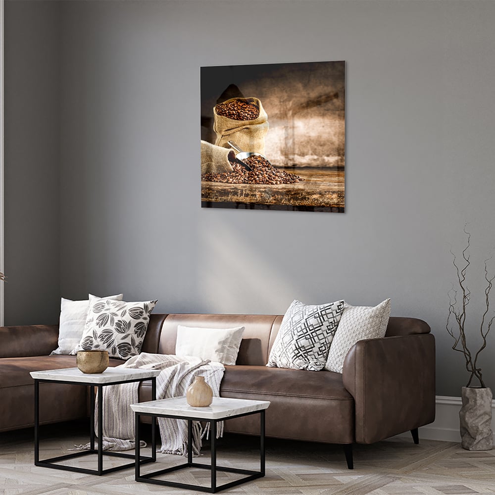 Glazen schilderij met koffiezakken en koffiebonen op een muur.