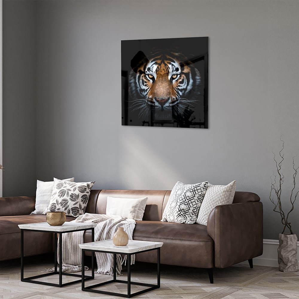 Glazen schilderij van een tijger met intense ogen, hangt aan de muur.