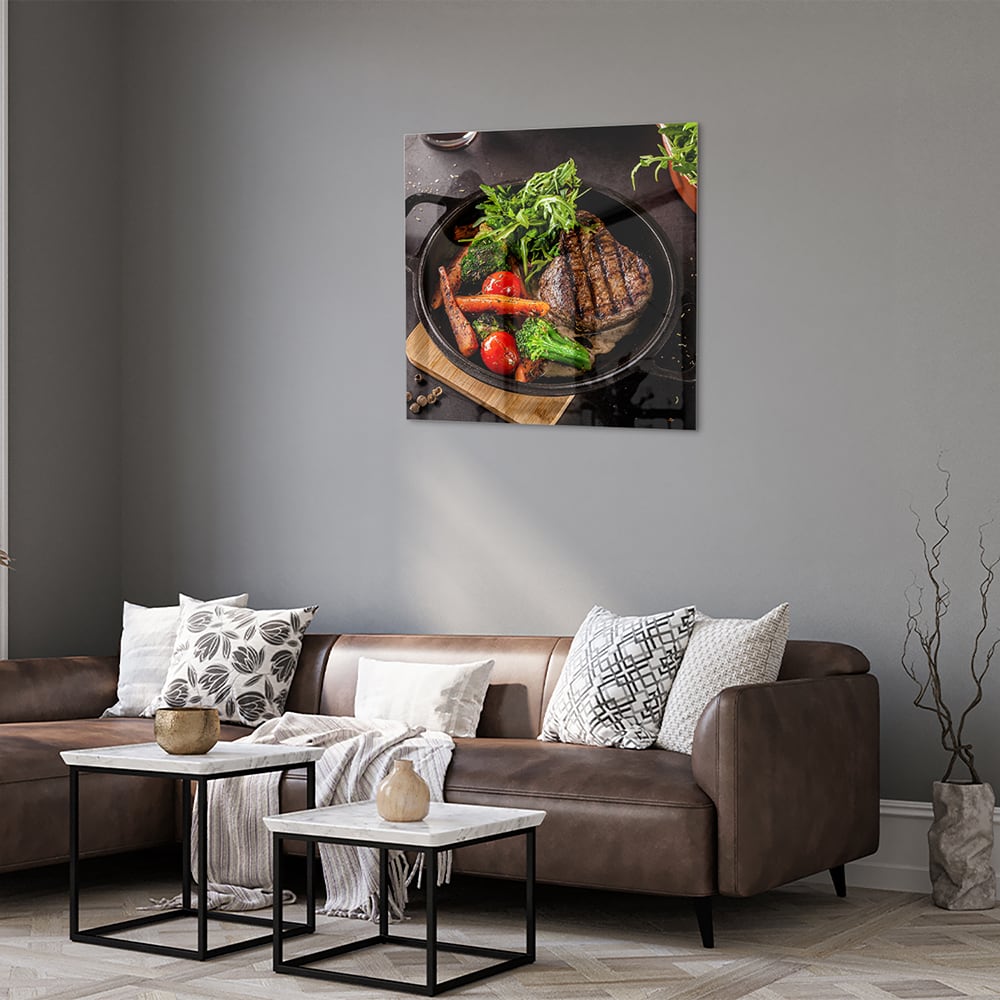 Glazen schilderij met een gegrilde steak en verse groenten in een pan