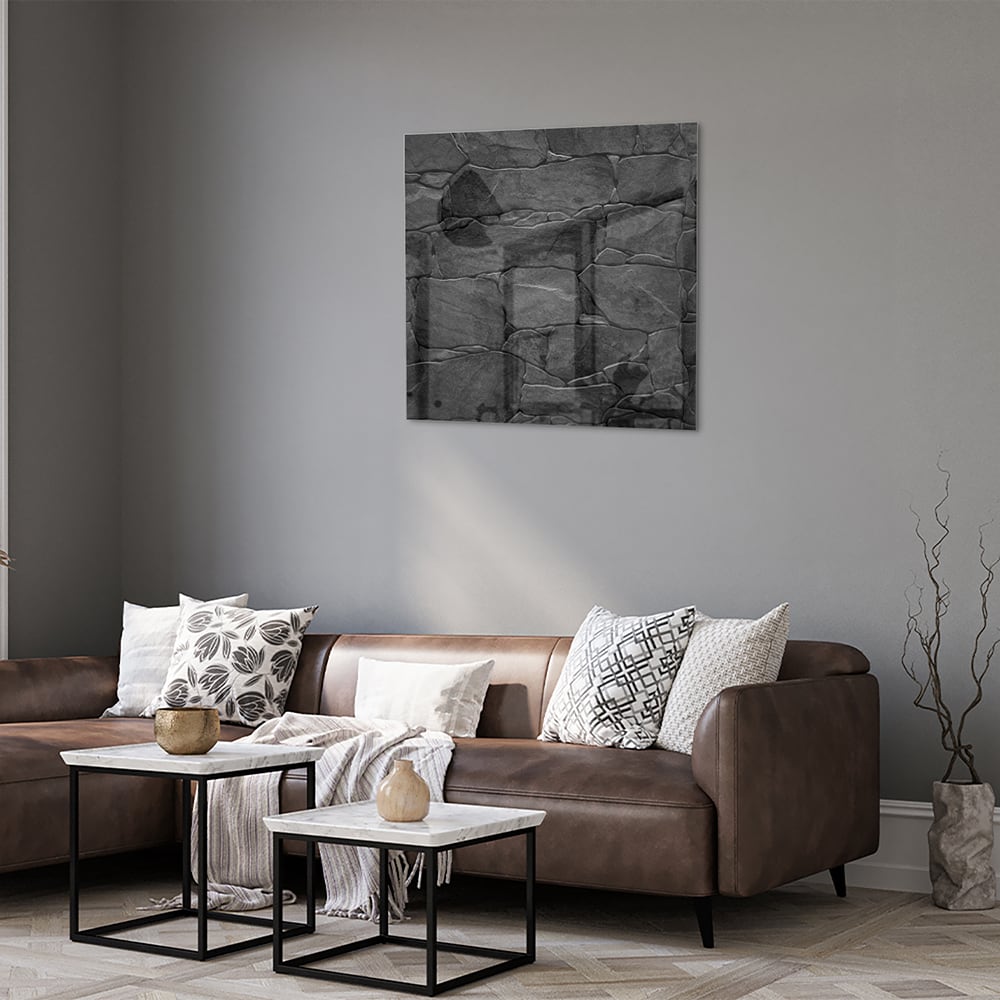 Moderne glazen schilderij in zwart en grijs hangt aan de muur.