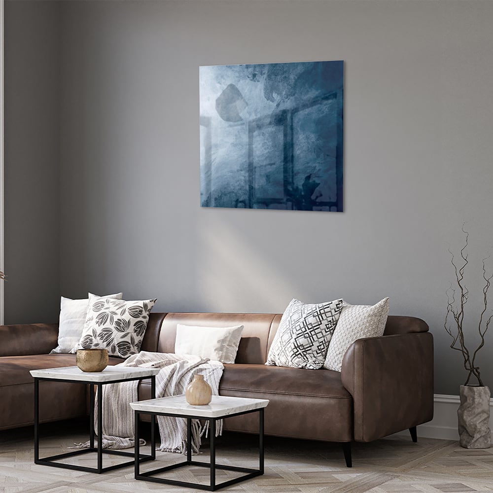 Abstract blauw glas schilderij aan de muur bij een houten meubel.