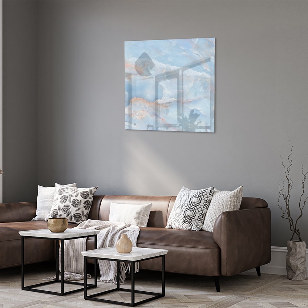 Abstract glazen schilderij in blauw en aardetinten aan de muur.