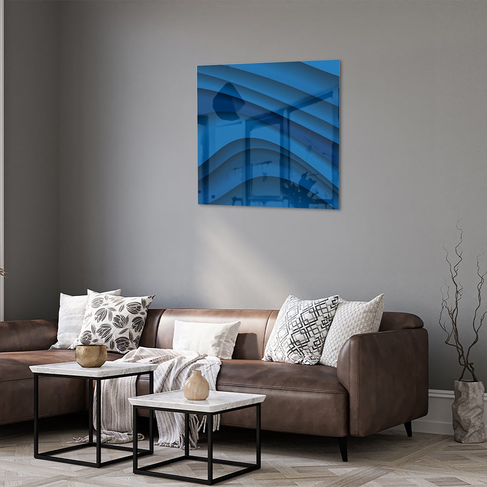 Modern glazen schilderij in abstracte blauwtinten op een muur.