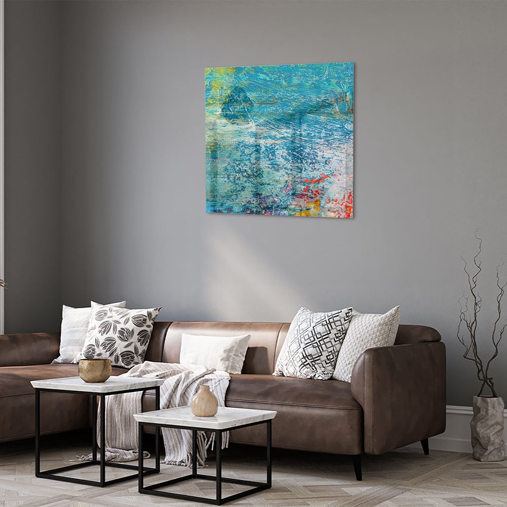 Kleurrijk abstract glazen schilderij aan de muur boven een houten kast