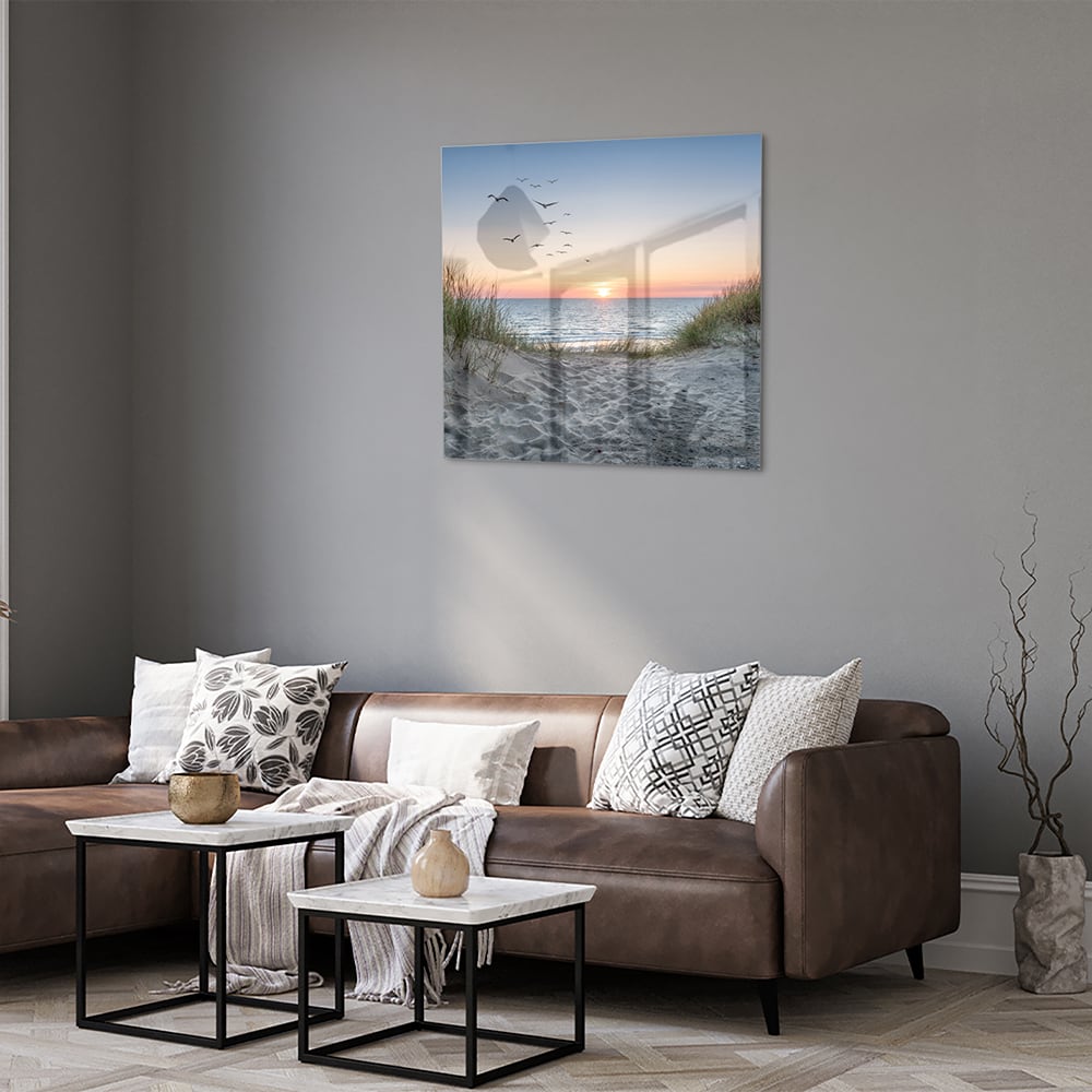 Glazen schilderij van een serene zonsondergang boven de zee met gras en vogels
