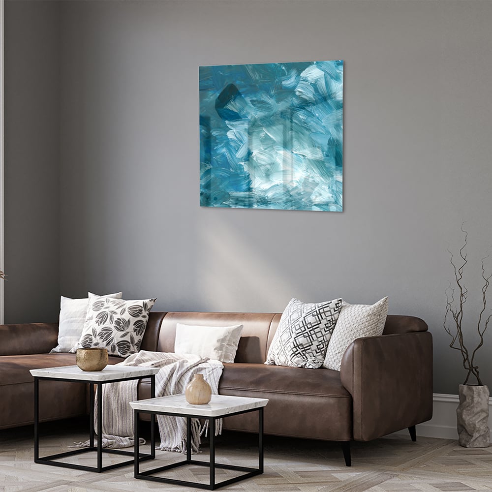 Abstract glazen schilderij met verschillende tinten blauw aan de muur.