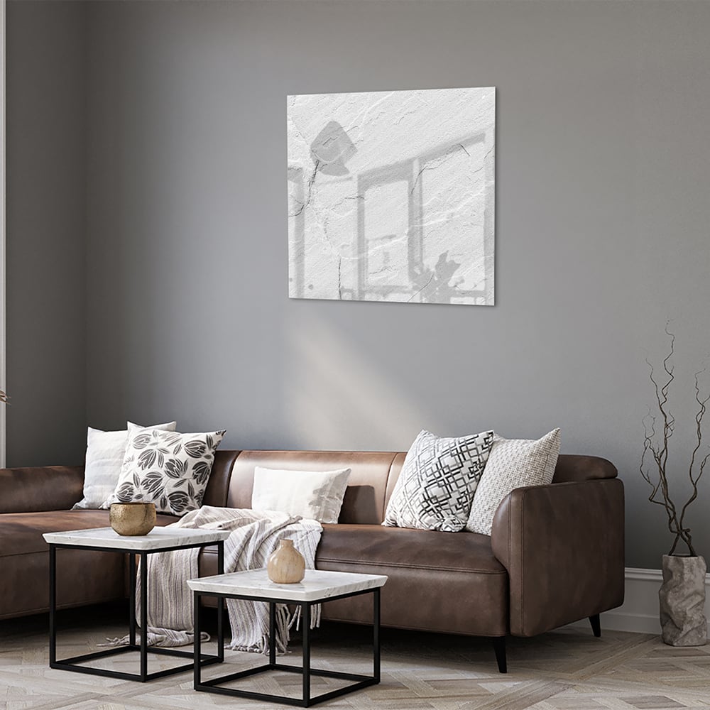 Minimalistisch glazen schilderij in grijstinten aan de muur boven een houten meubel.