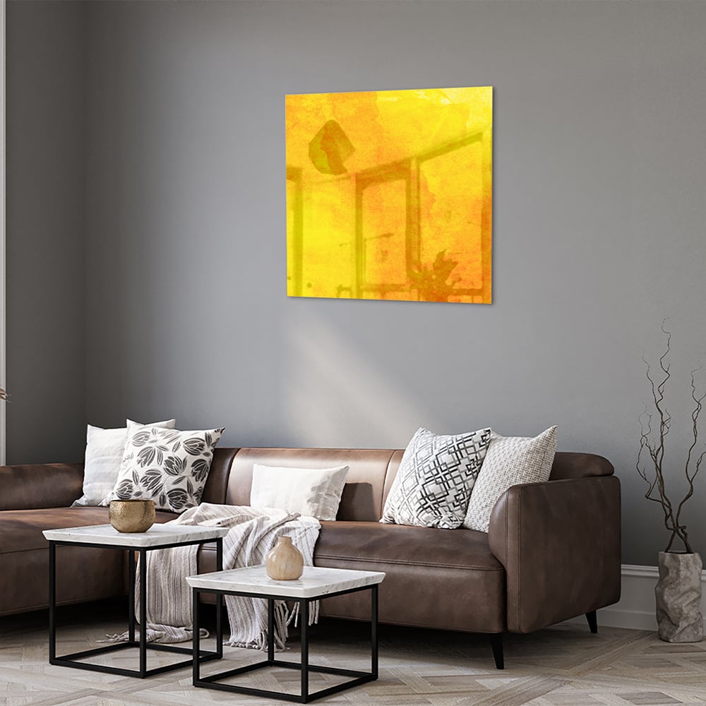 Gele glazen schilderij boven een houten bureau in een woonkamer.