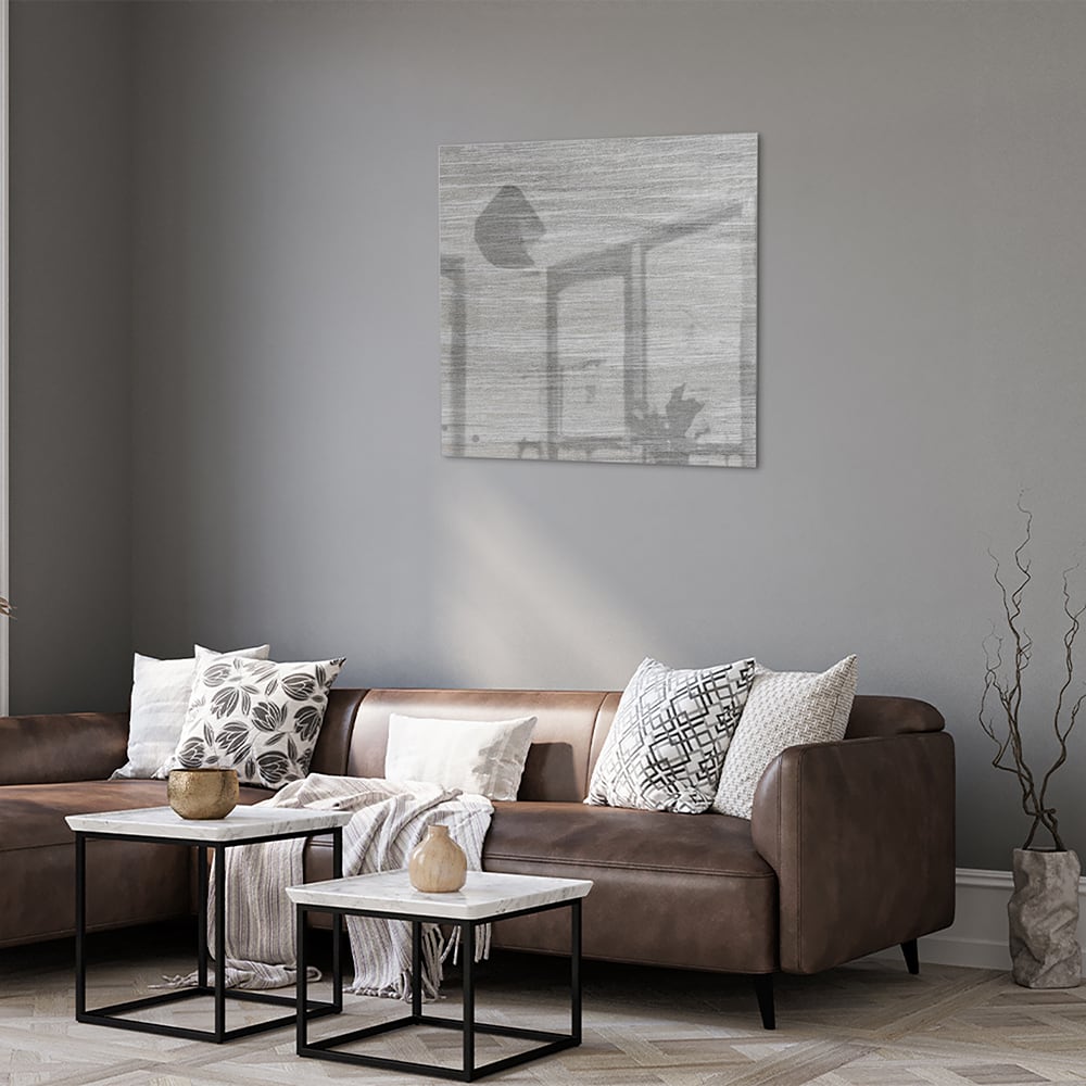 Minimalistisch glazen schilderij met grijstinten aan muur in moderne woonkamer.