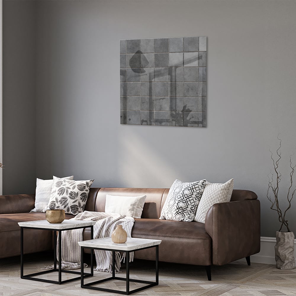Modern glazen schilderij in grijstinten aan de muur boven een houten kast
