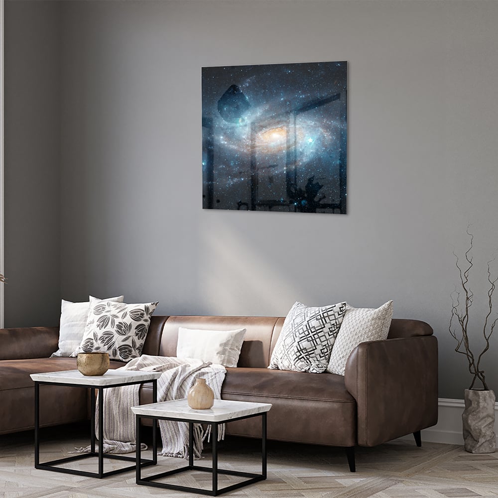 Glazen schilderij van een sterrenstelsel aan de muur in een moderne woonkamer.