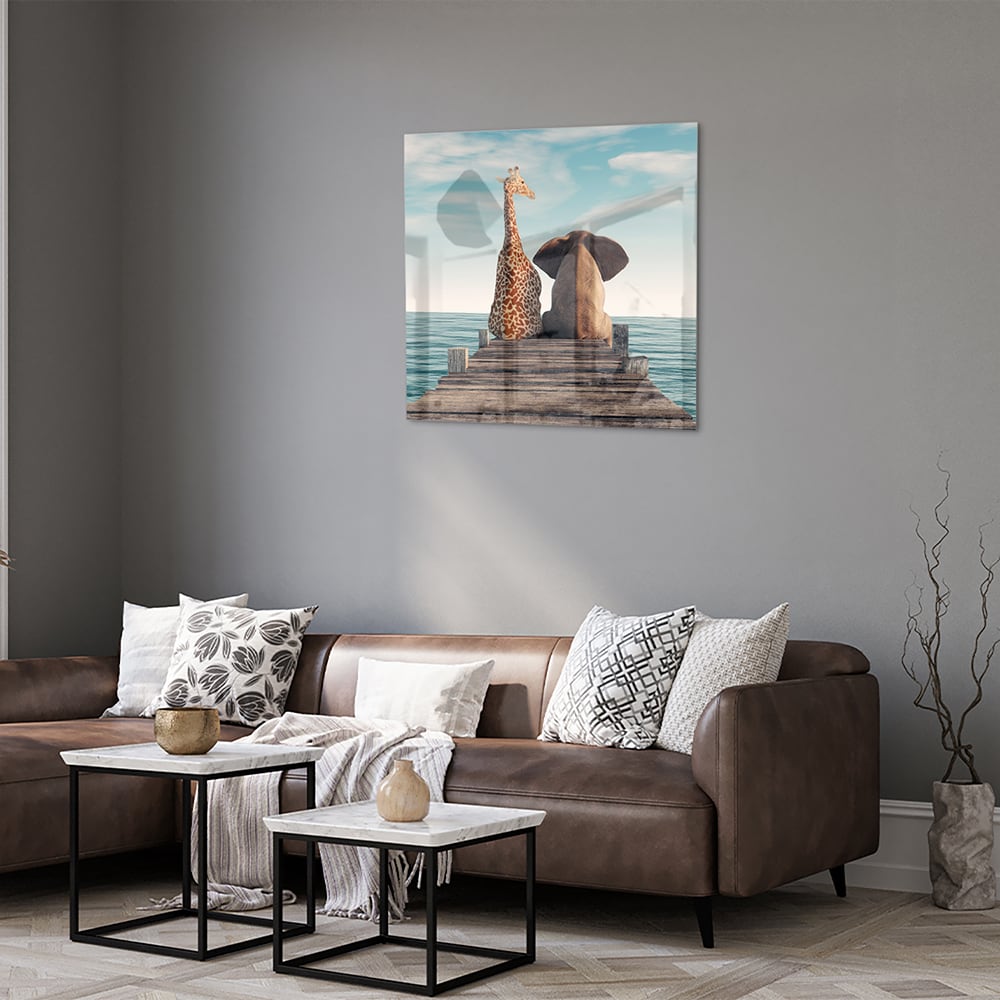 Glazen schilderij van een giraffe en olifant op een houten pier met zee op de achtergrond.