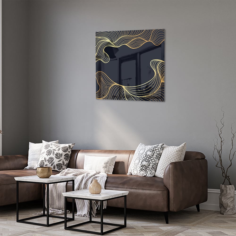 Glazen schilderij met gouden lijnen tegen een donkerblauwe achtergrond in een moderne woonkamer.