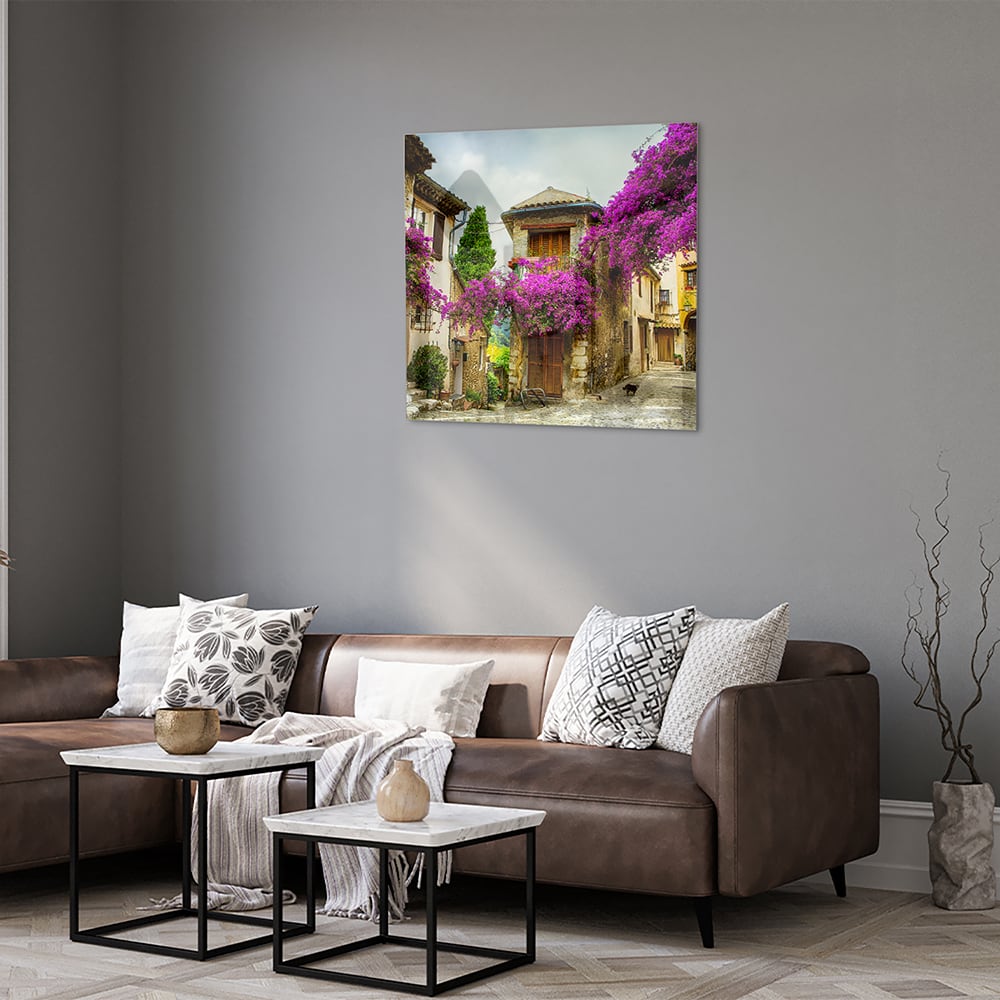 Glazen schilderij met een prachtig straatzicht en paarse bloesems in een helder interieur.