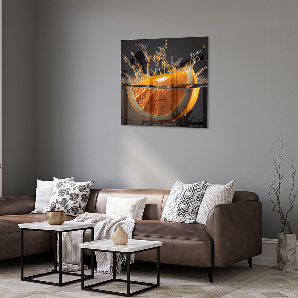 Glazen schilderij van een spetterende sinaasappel boven water.