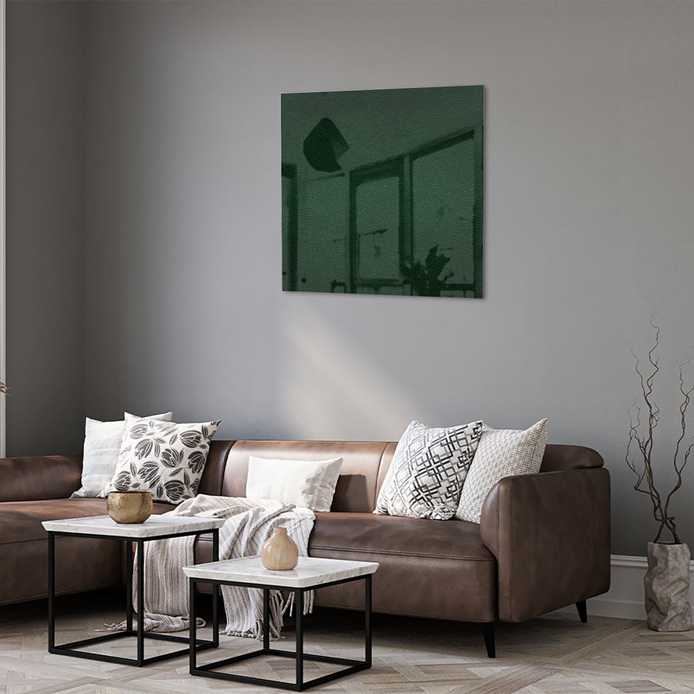 Een groen glazen schilderij aan de muur in een lichte woonkamer