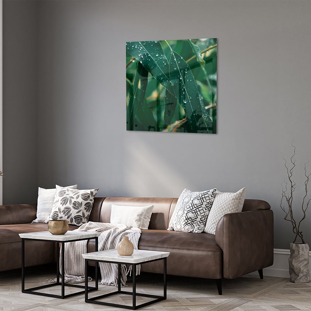 Glas schilderij van groene bladeren met dauwdruppels in een interieur