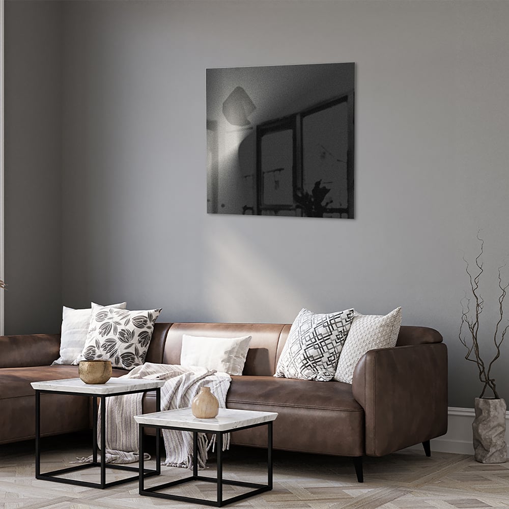 Moderne glazen schilderij op een witte muur in een stijlvolle woonkamer.