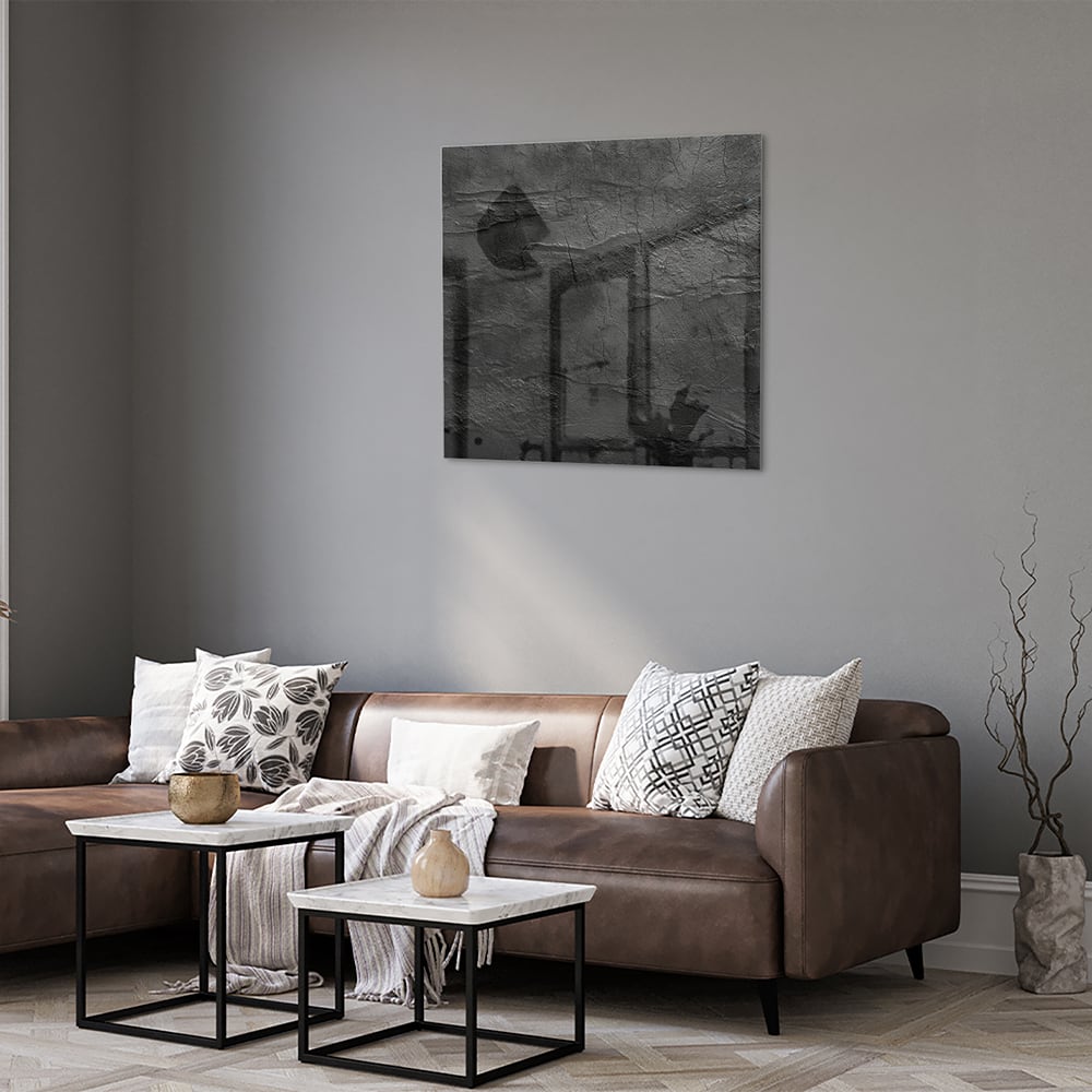 Abstract glazen schilderij in zwart en wit hangt aan de muur in een moderne woonkamer.